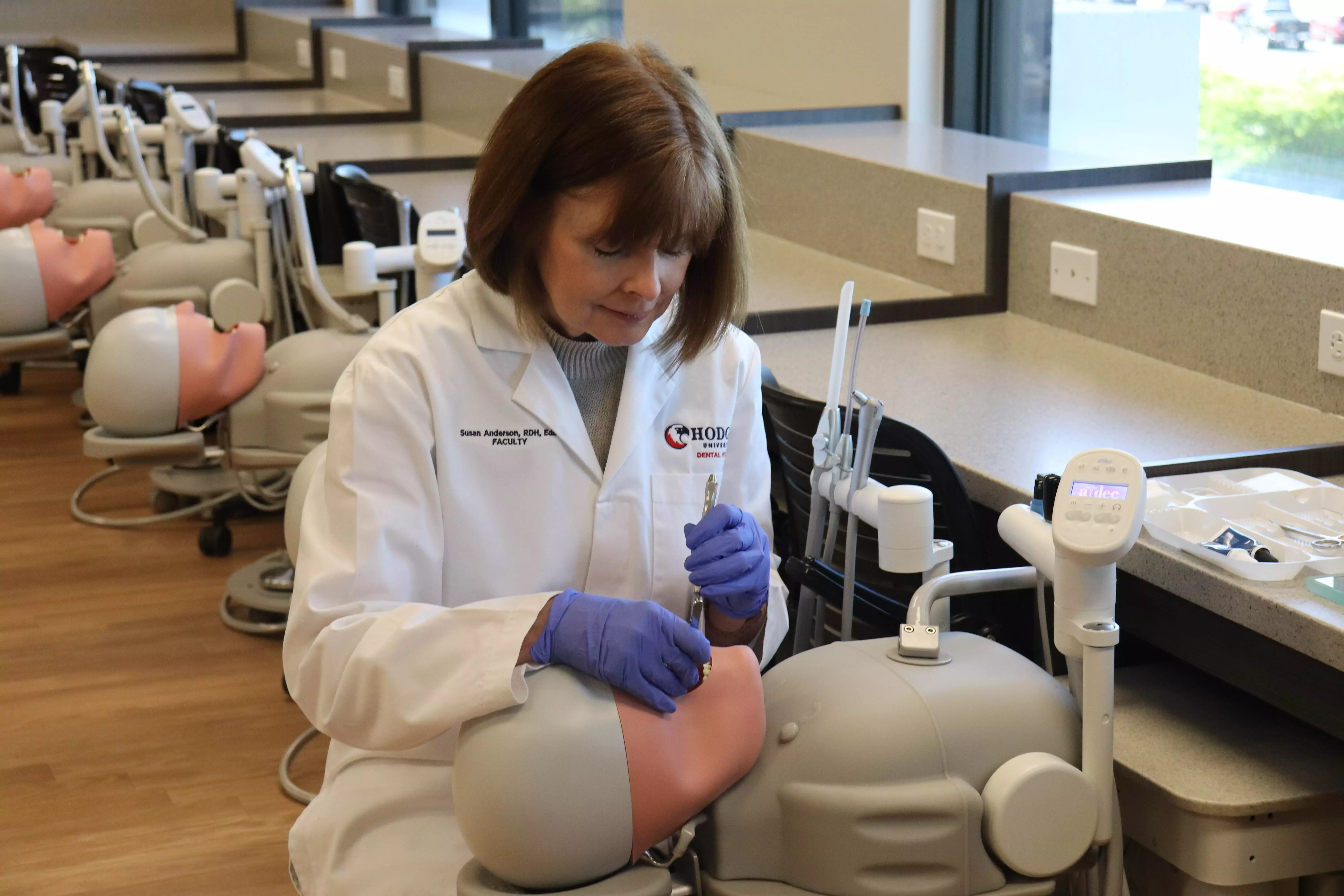 Dr. 苏珊·安德森在霍奇斯牙科实验室清洁机器人的牙齿