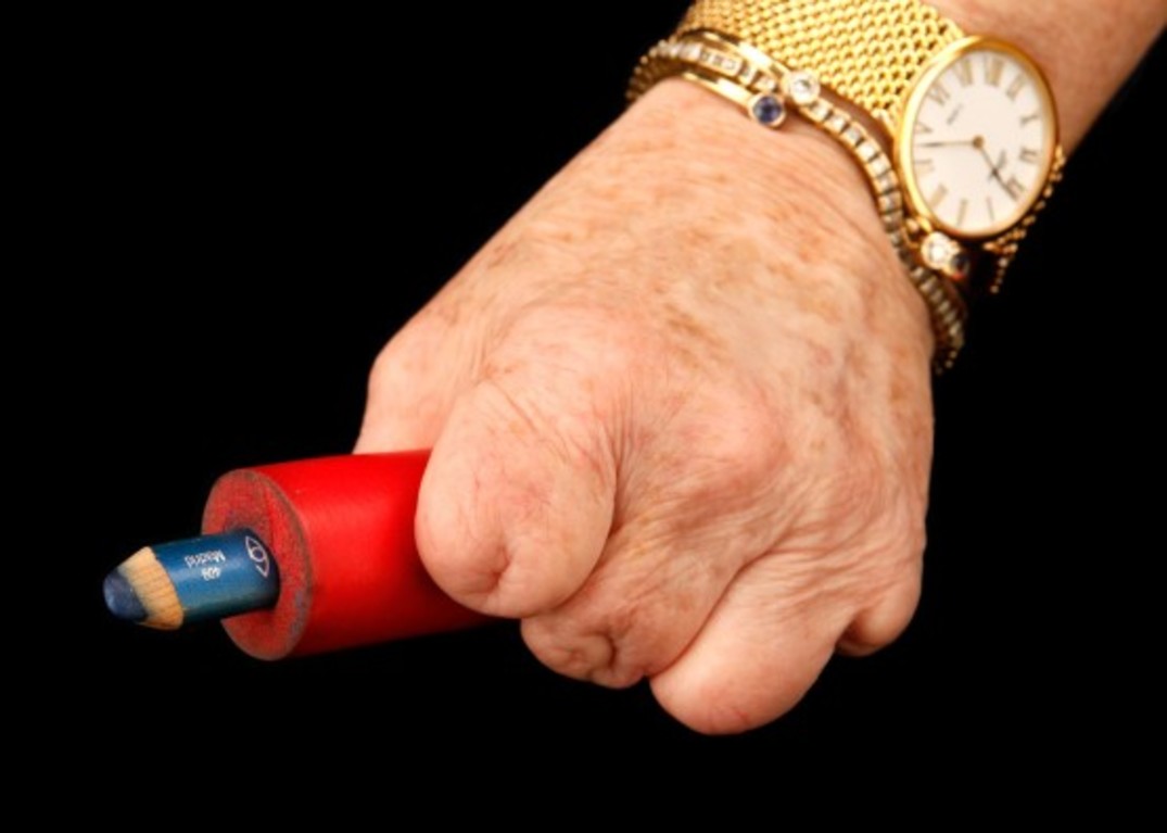 Cindy's hand grasps an eyeliner pencil, made accessible with soft tubing.