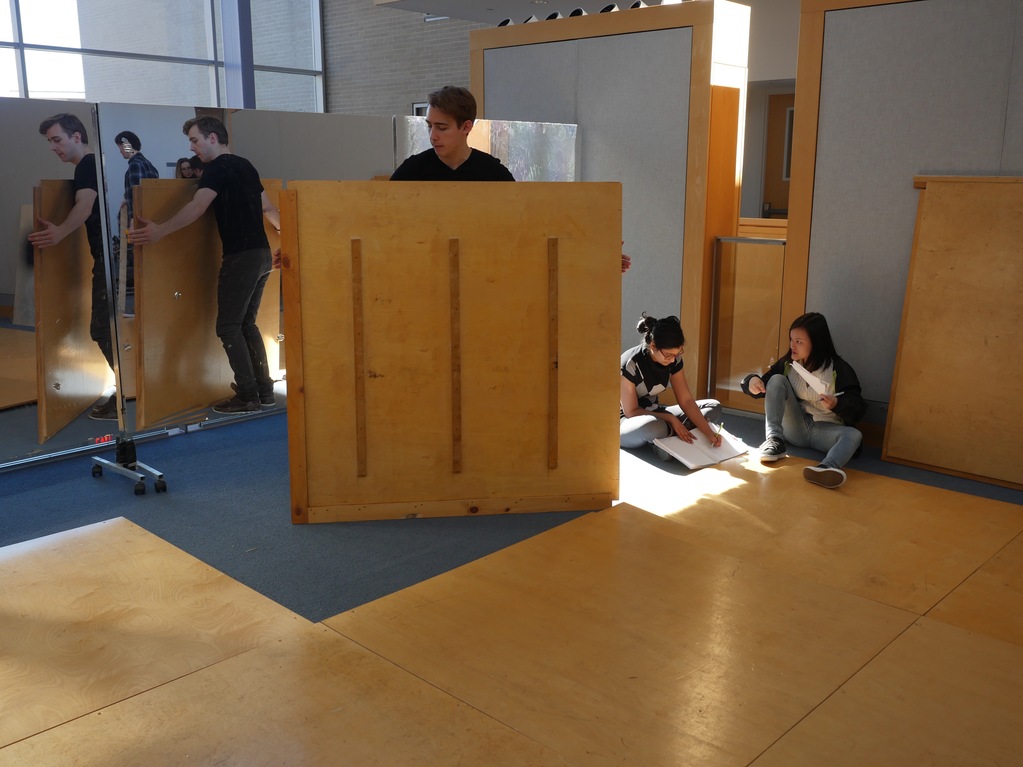 Students assemble the wood floor tiles in a modular pattern, with seven small ramps throughout.