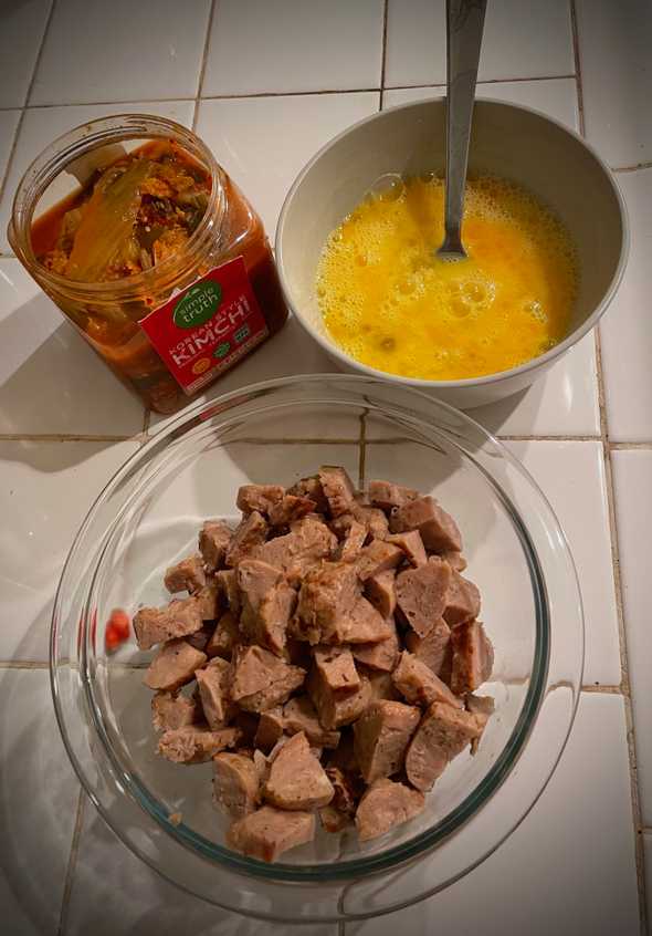 Kimchi, raw scrambled eggs, and chopped chicken prepped for cooking