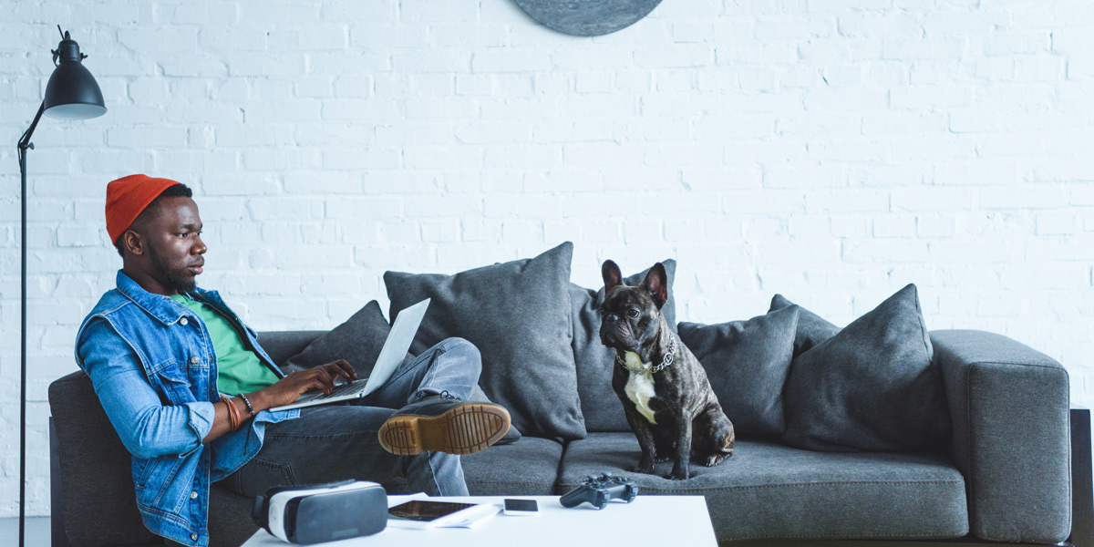 How to Switch from Graphic Design to UX Graphic designer sitting on a couch with his dog, considering switching to UX design.