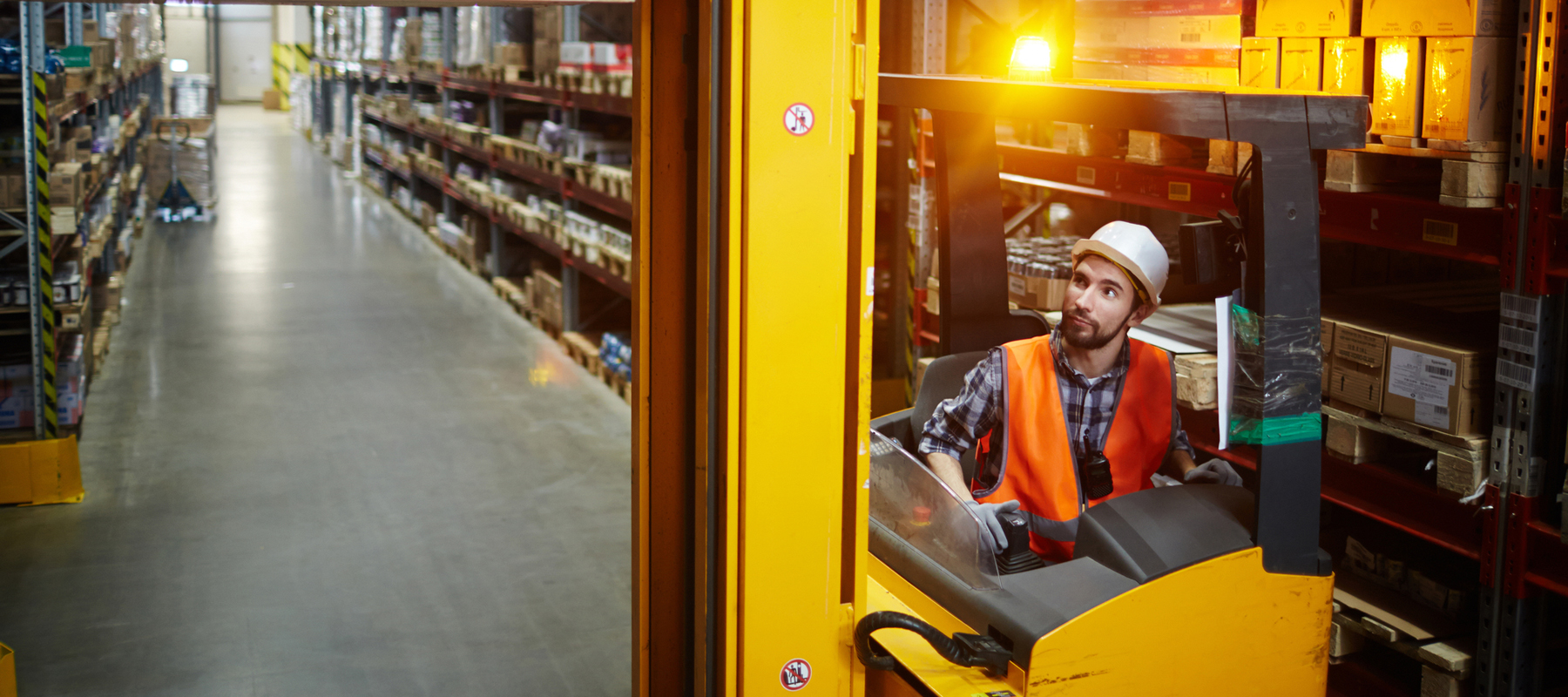 Worker Driving a Reach Forklift in a Warehouse