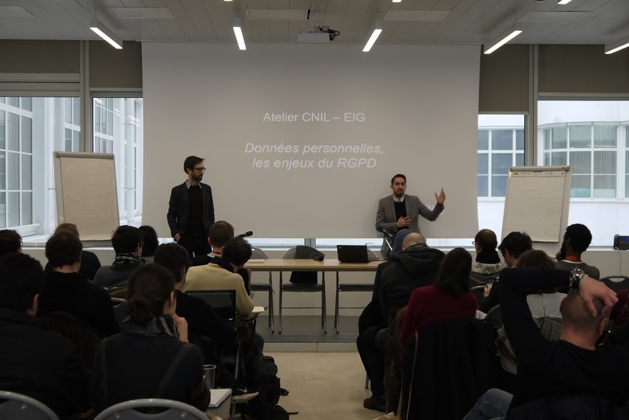 Deux hommes présentent devant un écran blanc où est projetée une présentation qui affiche "Atelier CNIL - EIG. Données personnelles, les enjeux du RGPD."