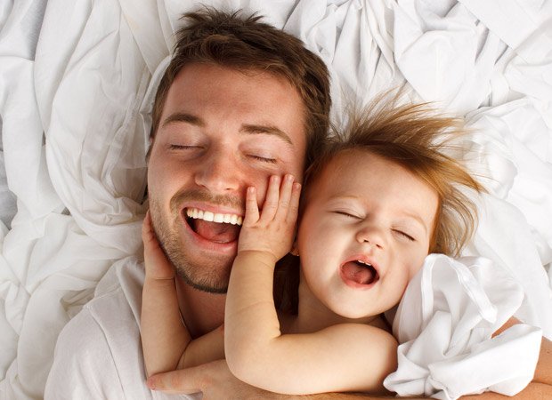 A father and baby laughing together