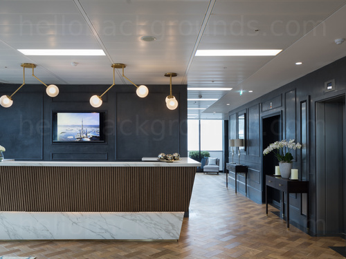 Suave reception desk style workspace with wooden tiled floor and prominent desk on corner of hallway decorated in dark blue Google Meet background