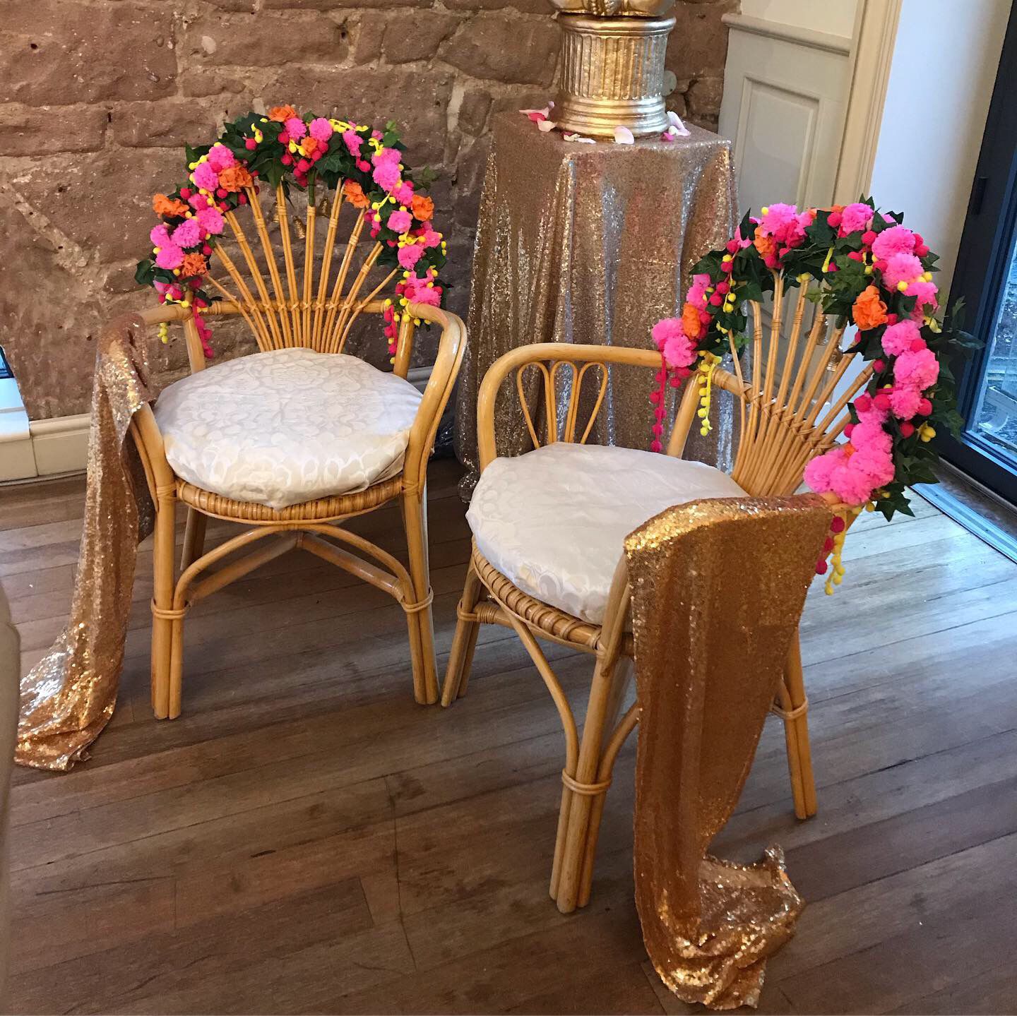 Two woven wooden chairs, with pretty flowers garnishing the edges.