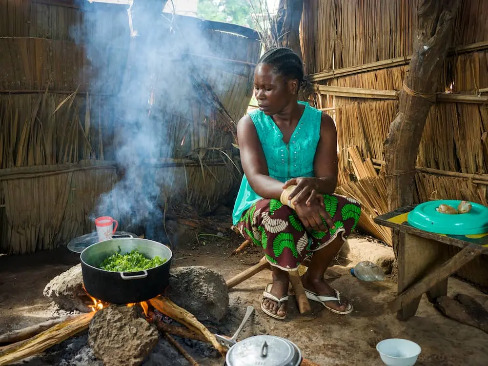 Mother-of-four Hermine Kounougoue (27) prepares a meal of amaranth leaves, peanut paste, and plantain after a cooking demonstration with her neighbor Nadine Doko, a Concern-supported Mama Lumiere – or “lead mother.”