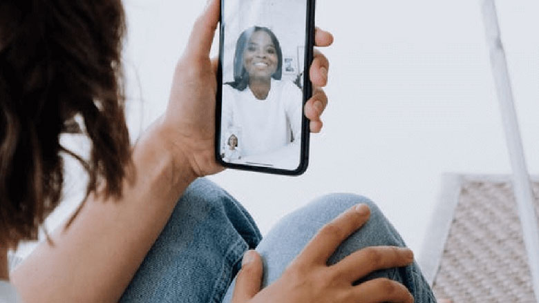 Image of a woman at home having a video chat on her phone.