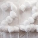 Twenty two formed from a bunch of cotton balls on a tissue backdrop.