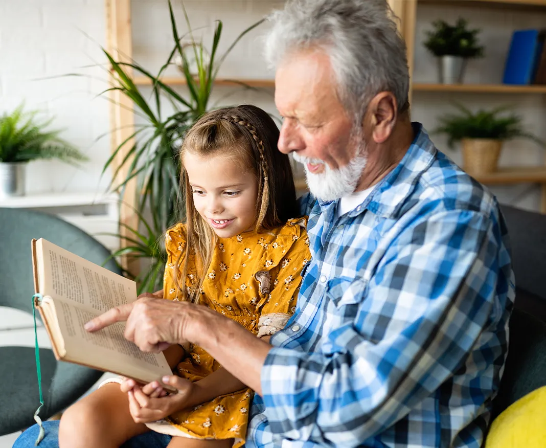 Man reading to granddaughter
