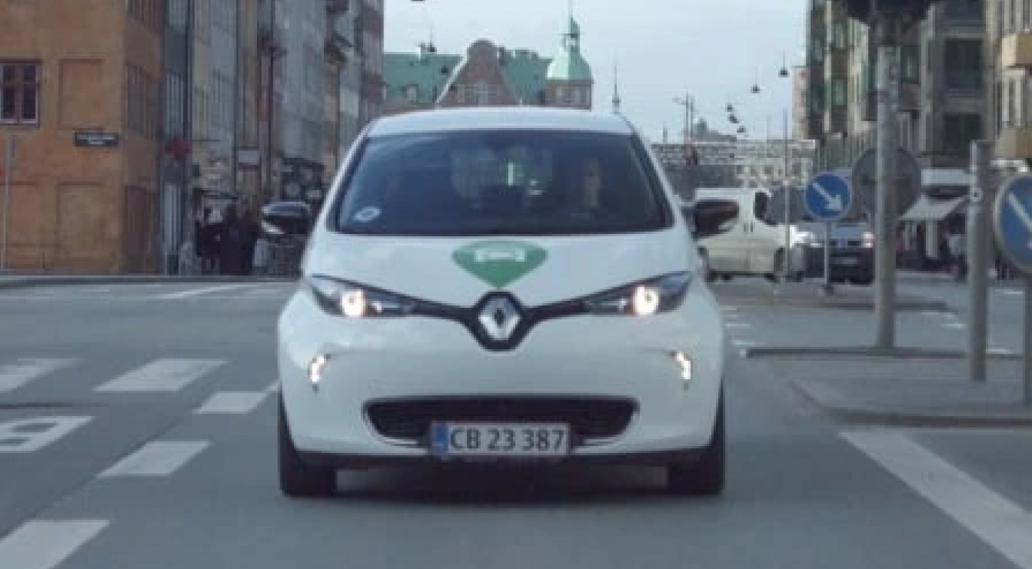 GreenMobility customer image card of a Green Mobility sharing car driving on the streets of Copenhagen.