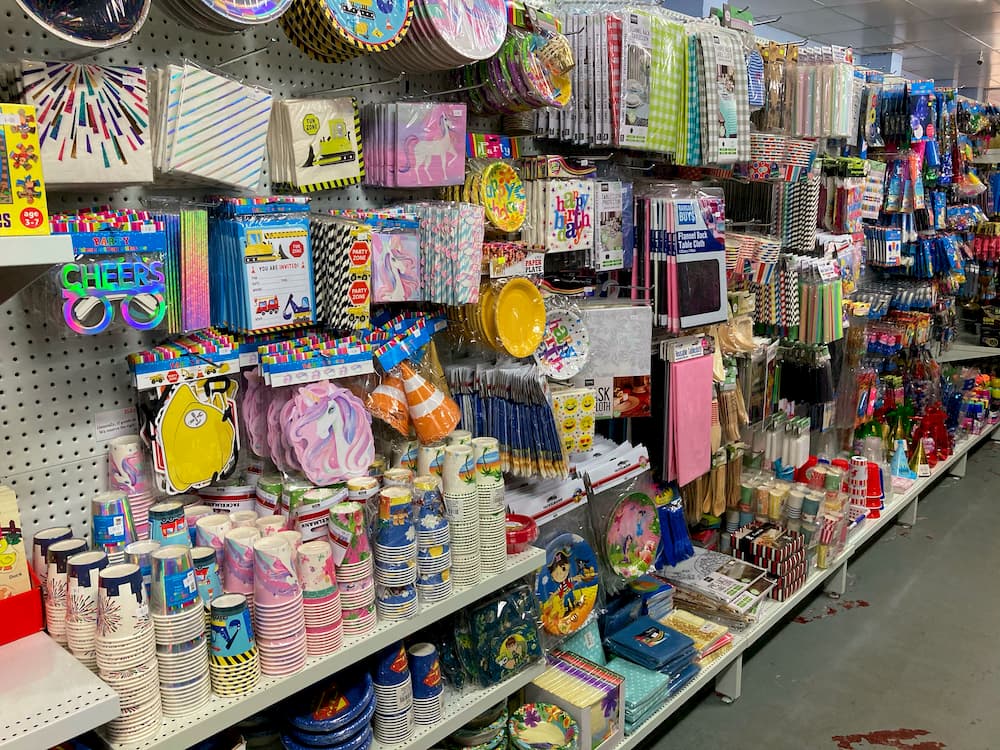 Party supplies, including cups, napkins, cutlery, party hats, balloons, table cloths, toys, and more.