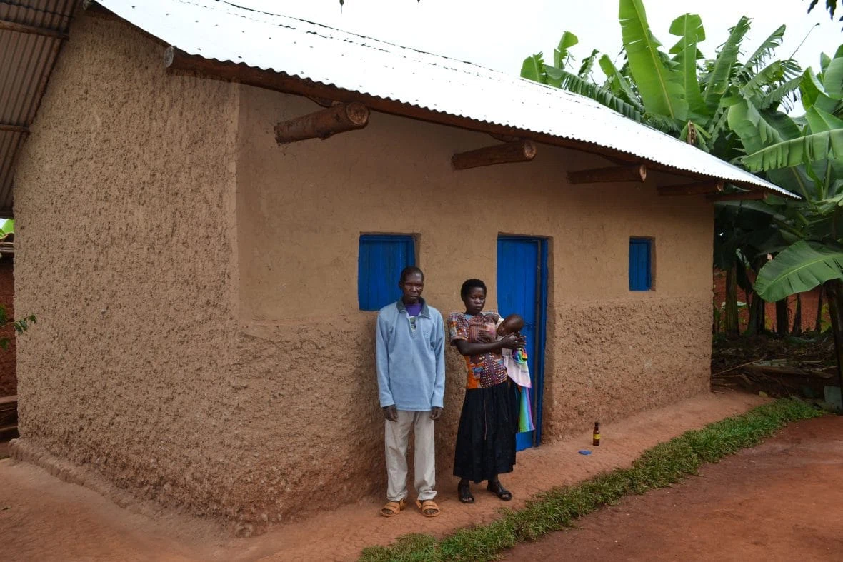 Sylvere Ndayambaje, who took part in Concern’s graduation program, with his family outside their new home in Rwanda.