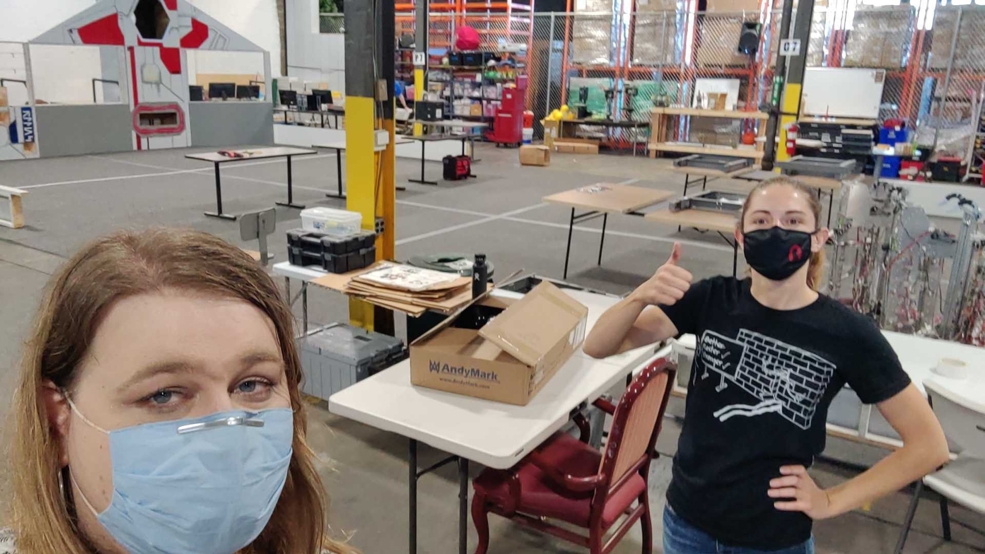 A photo of Maggie and I, both mentors for the Girls of Steel FIRST 
    Tech Challenge team, at the practice field assembling it for the 2021-2022 
    competition.
