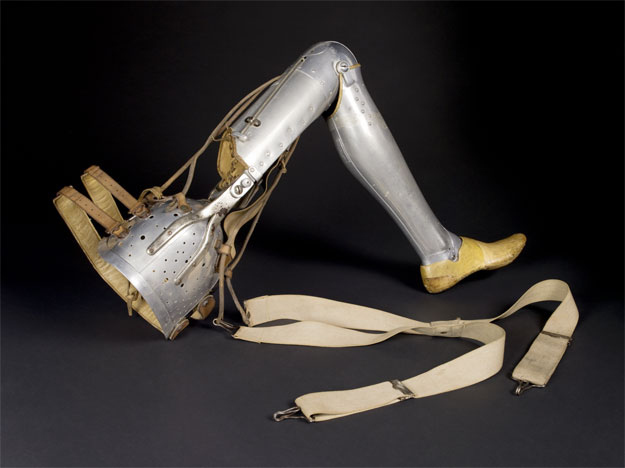 a "hip disarticulation leg," from 1928. Metal limbs mimic the human form, with a colander-like bowl for the hip and canvas strap attachments
