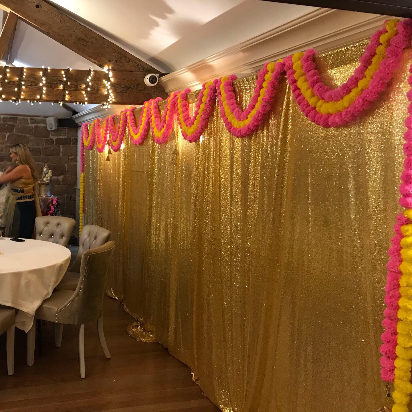 A beautiful golden and flowered backdrop for an Indian wedding breakfast