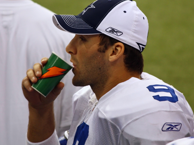 NFL QB Tony Romo of the Dallas Cowboys drinking a cup of water that NFL Waterboy gave to him