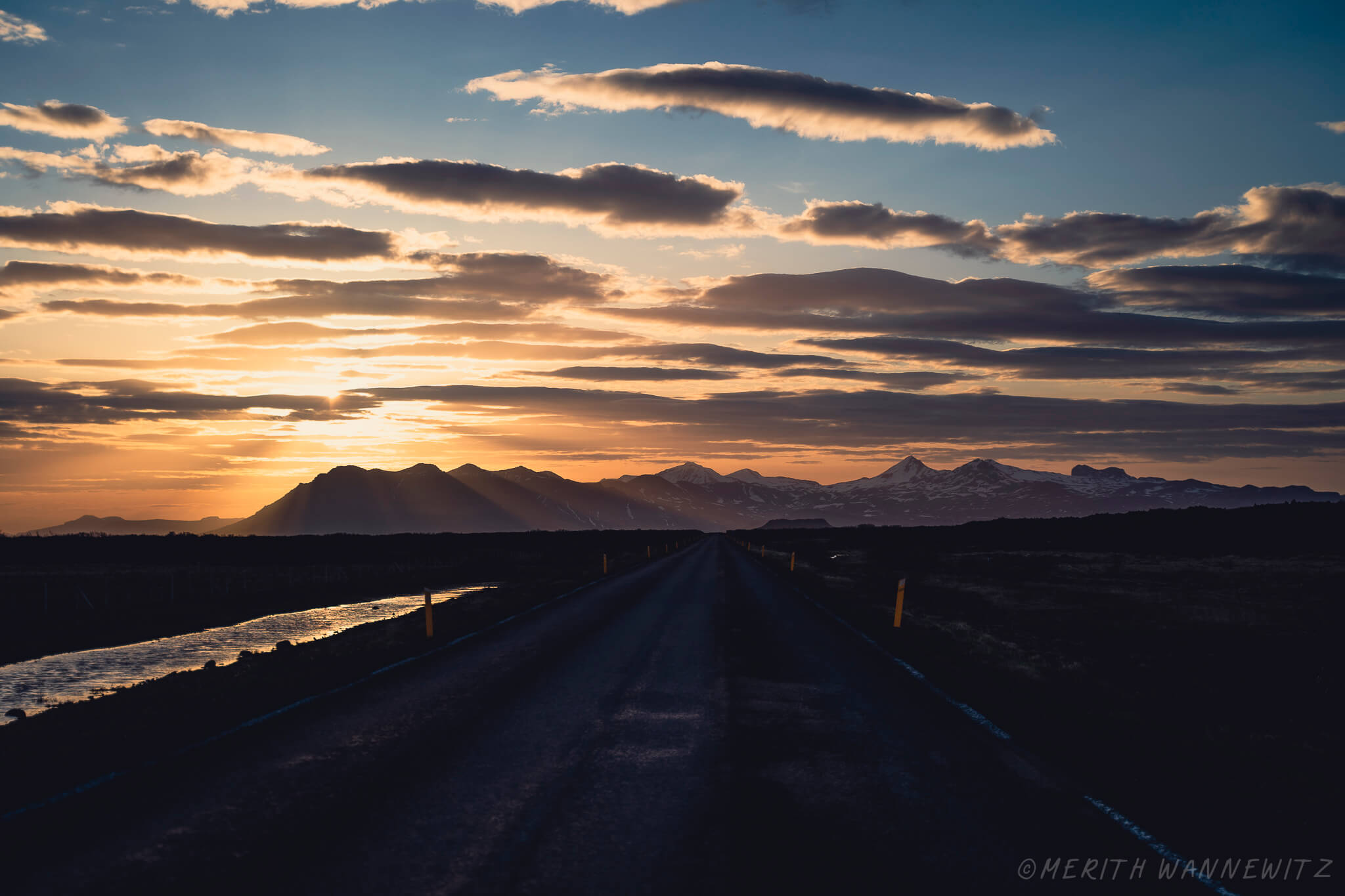 Sunset over the skyline of Snæfellsnes in Iceland, a road heading towards the mountains.