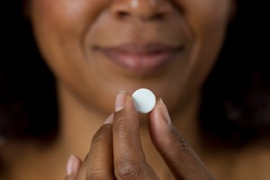 Woman holding white pill contraceptive safe sex