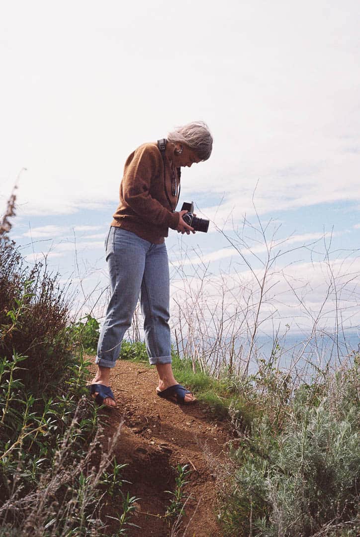 A woman on a high-up path taking a photograph
