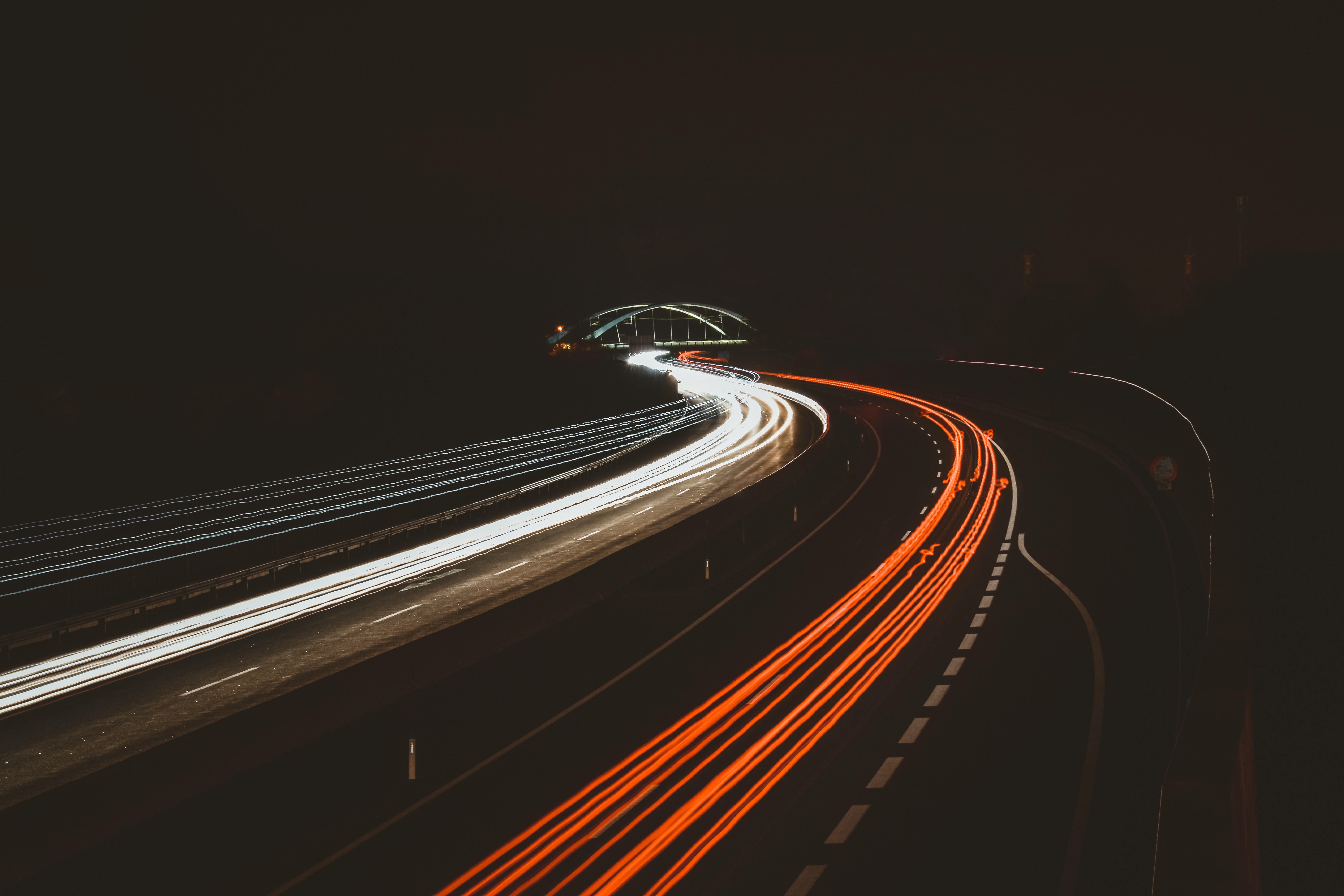 Cars driving fast on a freeway at night
