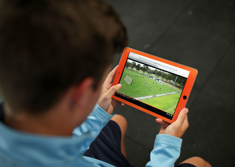Soccer player watches gameplay on tablet