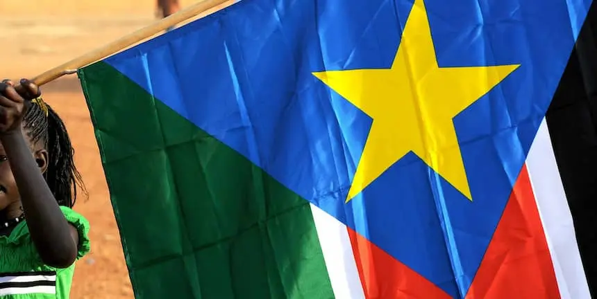 A young girl holds the South Sudan flag