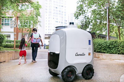 A photograph of the four-wheeled, white-coloured Camello robot which delivers groceries to Punggol residents.