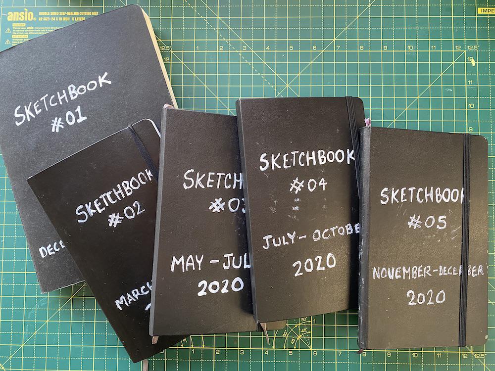 A photo of 5 completed sketchbooks by Adam Westbrook
