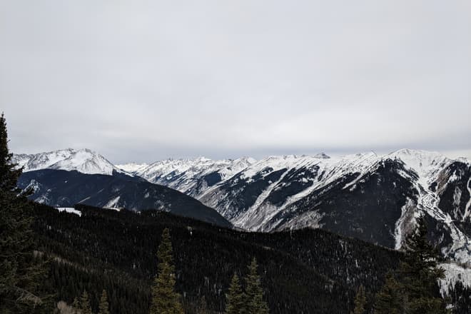 Snow-capped mountains border a steep valley. The winter sky is cold and gray.