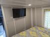 Gooseneck tiny house from Greensburg, PA; a view of the master bedroom with a large bed and wall-mounted television. Gooseneck tiny house from Greensburg, PA; a view of the master bedroom with a large bed and wall-mounted television.