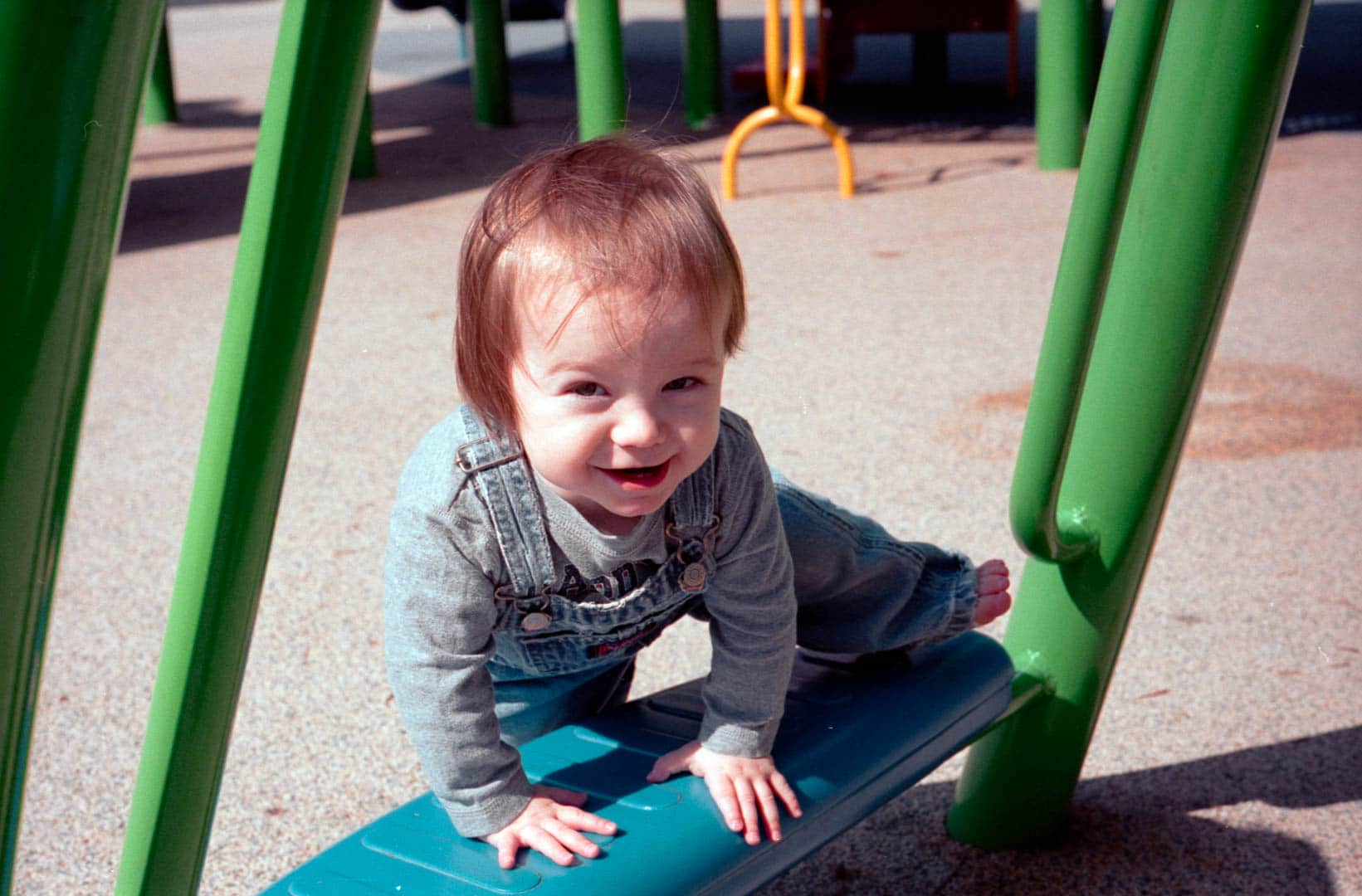 A young toddler climbs on a playground
