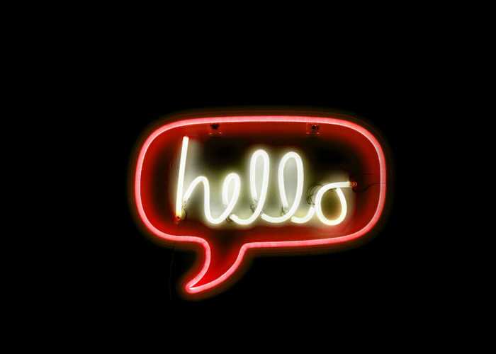 Chat bubble neon sign with the word “hello” in it