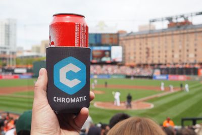 A picture of a can of soda in a Chromatic koozie