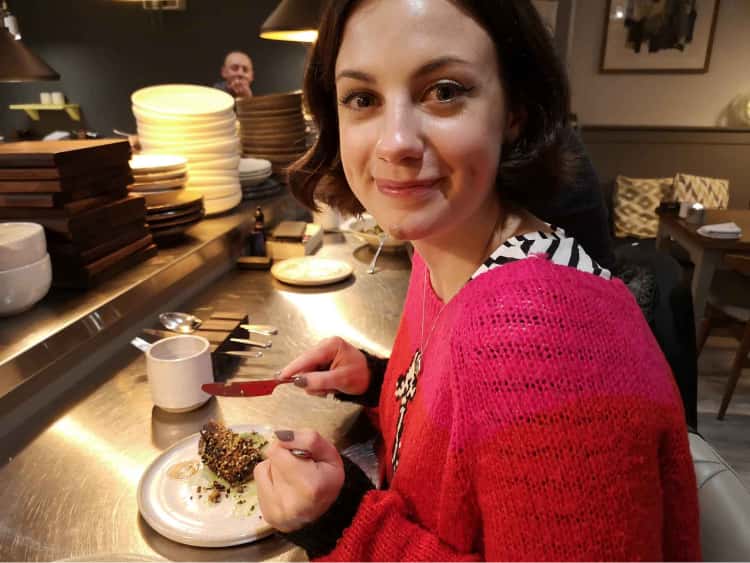 Naomi ready to tuck into some food, sat at the counter of Skosh, a restaurant in York.