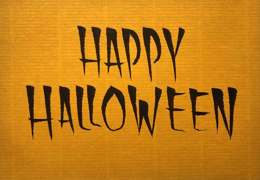 “Happy Halloween” brush lettered on dark yellow paper.