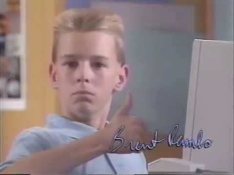A kid at his computer giving a thumbs up