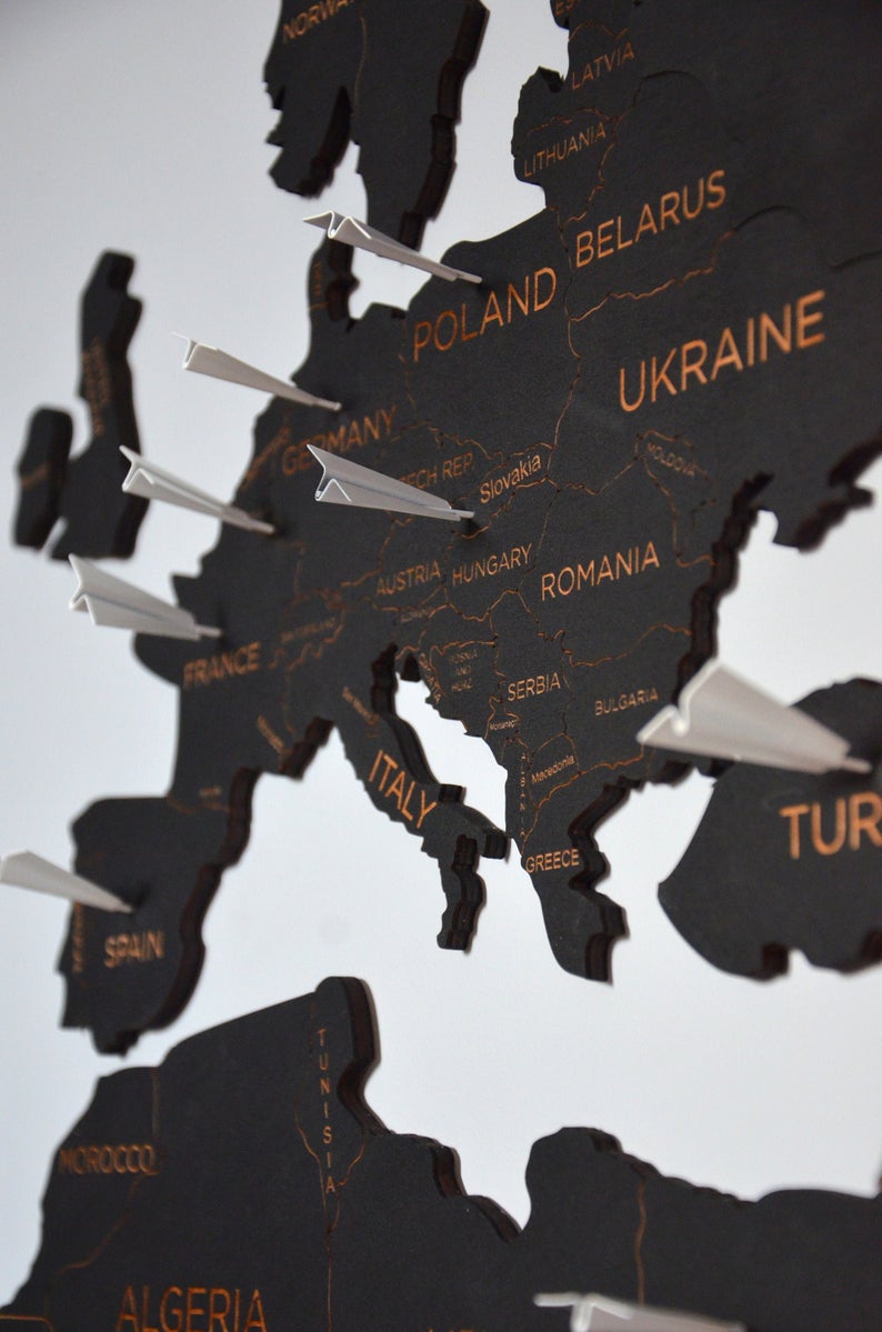 large wooden world map decorated with white push pins