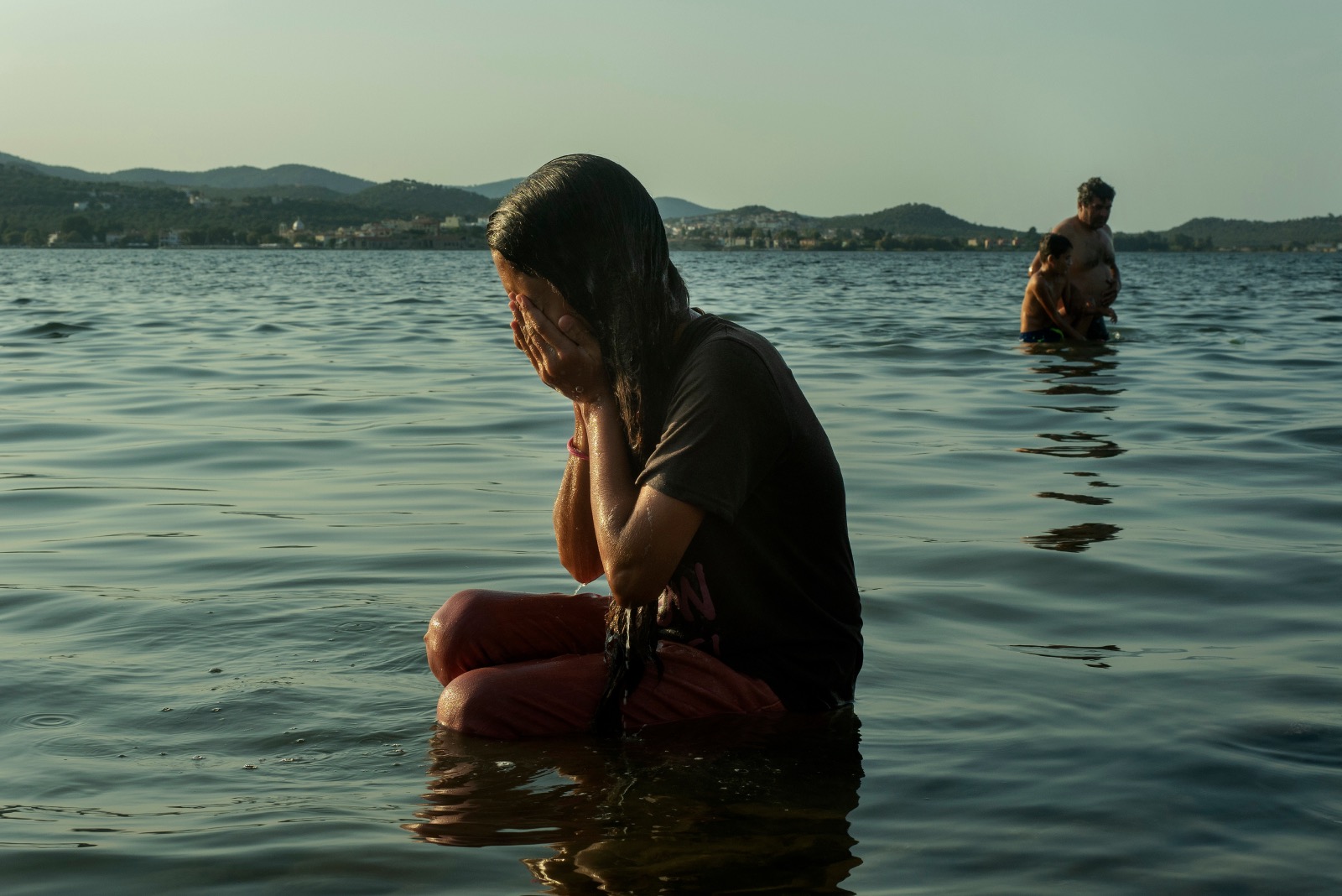 child sitting in water hands on face