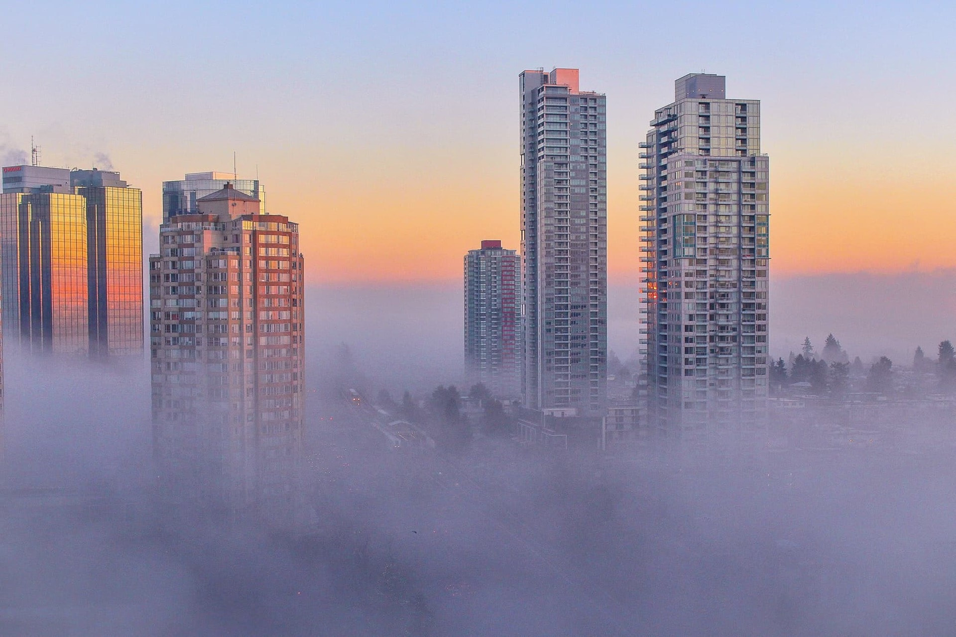 Foggy sky and skyscrapers reaching through the fog in a Canadian city.