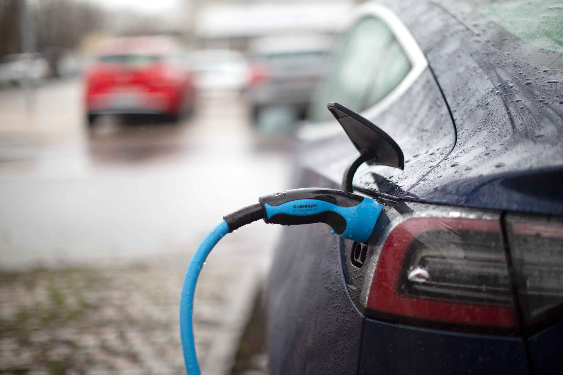 Electric car with charger plugged in.