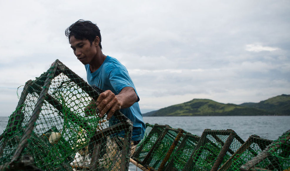 Filipino fisherman works on his boat after Typhoon Haiyan