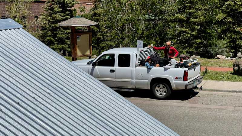 Hikers leaving town in the back of a pickup truck