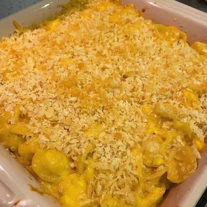 Add the cooked pasta and the cooked chicken to the cheese sauce and stir well to coat and combine. Add in the blue cheese crumbles if using and gently mix to distribute.
Dump the pasta mixture into the greased pan and spread toasted breadcrumbs in an even layer on top.