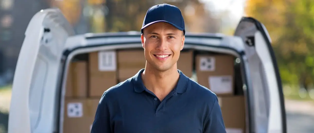 Delivery man standing in front of truck with delivery boxes