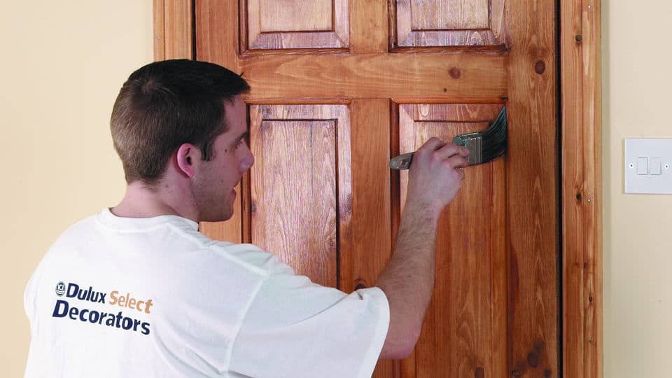 man painting a wooden door