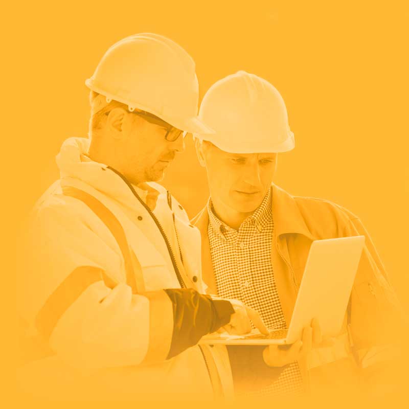 two a man wearing a hard hat looking at a computer