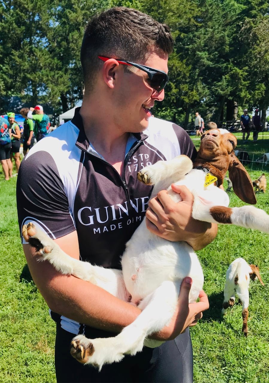 Me holding a baby goat that definitely doesn't want to be held