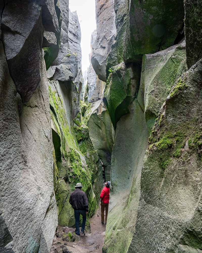 Two men walking in the Crack in the Ground looking up the walls