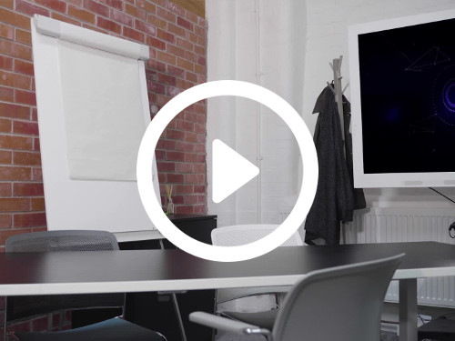 Intimate meeting space featuring exposed brick walls and white flipboard with black table surrounded by grey mesh chairs  Zoom background